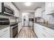 Modern kitchen featuring stainless steel appliances, granite countertops, and sleek white cabinetry at 5006 Lodgewood Dr, Lakeland, FL 33810