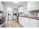 Bright kitchen features white cabinetry, stainless steel appliances, granite counters and wood grain tile floors at 5006 Lodgewood Dr, Lakeland, FL 33810