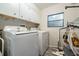 Bright laundry room features a washer, dryer, storage cabinets, and a window for natural light at 5006 Lodgewood Dr, Lakeland, FL 33810