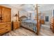 Bedroom with wood four poster bed, matching wood furniture, a ceiling fan and wood grain floors at 5006 Lodgewood Dr, Lakeland, FL 33810