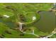 Picturesque aerial view of a lush green golf course with winding paths, ponds, and footbridges on a sunny day at 6922 Wendy Way, The Villages, FL 34762