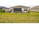 Serene backyard featuring a screened lanai and well-maintained lawn, creating an ideal outdoor space at 6922 Wendy Way, The Villages, FL 34762