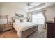 Bright bedroom with neutral tones, tray ceiling, and a large window for natural light at 6922 Wendy Way, The Villages, FL 34762