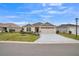 Beautiful home with a well-manicured lawn, stylish driveway, and an attached two-car garage under a sunny sky at 6922 Wendy Way, The Villages, FL 34762