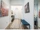 Inviting entryway featuring stylish decor, a blue tufted bench, and hardwood floors at 6922 Wendy Way, The Villages, FL 34762