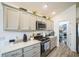Modern kitchen with stainless steel appliances, quartz countertops, and ample cabinet space at 6922 Wendy Way, The Villages, FL 34762