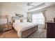 Tranquil main bedroom featuring a tray ceiling, carpet, and ample natural light at 6922 Wendy Way, The Villages, FL 34762