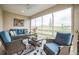 Inviting sun room featuring cozy seating, bright cushions, a ceiling fan, and large windows with serene views at 6922 Wendy Way, The Villages, FL 34762