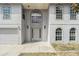 Front entrance with a decorative door, arched windows, and a well-manicured lawn at 6087 Sunset Vista Dr, Lakeland, FL 33812