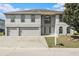 Inviting two-story home with a two-car garage and arched windows, creating a charming curb appeal at 6087 Sunset Vista Dr, Lakeland, FL 33812
