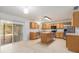 Bright kitchen with stainless steel appliances, a central island, and sliding glass doors leading to the outdoors at 6087 Sunset Vista Dr, Lakeland, FL 33812