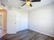 This bedroom has gray wood-look floors, closet, and a ceiling fan at 703 New York Ave, South Daytona, FL 32119