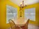 Bright dining area with a chandelier and natural light from two large windows at 703 New York Ave, South Daytona, FL 32119
