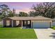 Charming single-story home featuring a well-manicured lawn, attached two-car garage, and classic architectural details at 703 New York Ave, South Daytona, FL 32119