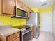 Modern kitchen with stainless steel appliances, wooden cabinets, and tile flooring at 703 New York Ave, South Daytona, FL 32119