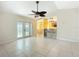 Spacious living area with tile flooring, ceiling fan, and an open layout that connects to the kitchen and dining area at 703 New York Ave, South Daytona, FL 32119