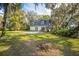Backyard of the two-story home with lush greenery, mature trees, and a private patio area at 9401 Cat Track Trl, Lake Wales, FL 33898