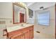 Bathroom vanity with marble countertop, wood cabinets and a decorative framed mirror at 9401 Cat Track Trl, Lake Wales, FL 33898