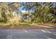 Charming exterior view of a two-story home with a staircase and lush landscaping surrounded by mature trees at 9401 Cat Track Trl, Lake Wales, FL 33898
