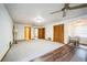 Large living room with multiple doors and ceiling fans, featuring both carpet and hardwood floors at 9401 Cat Track Trl, Lake Wales, FL 33898