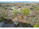 A scenic aerial view of a home nestled among lush trees with direct access and views overlooking a tranquil lake at 3322 Heather Glynn Dr, Mulberry, FL 33860