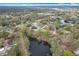 Enjoy this peaceful aerial view of a residential area featuring homes nestled along a serene lake, surrounded by lush greenery at 3322 Heather Glynn Dr, Mulberry, FL 33860