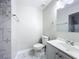 Bright bathroom featuring a vanity with sink, toilet, and tiled shower with mosaic accents at 3322 Heather Glynn Dr, Mulberry, FL 33860