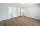 Spacious bedroom with wood-look flooring, light gray walls, and a view into an attached bathroom at 3322 Heather Glynn Dr, Mulberry, FL 33860