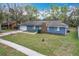Attractive one-story home featuring blue siding, a brick chimney, and a green front lawn at 3322 Heather Glynn Dr, Mulberry, FL 33860
