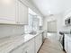 Modern kitchen with stainless appliances, white cabinets, and updated marble countertops at 3322 Heather Glynn Dr, Mulberry, FL 33860