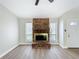 Living room with updated flooring, brick fireplace and two windows at 3322 Heather Glynn Dr, Mulberry, FL 33860
