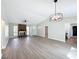 Open living space boasts a brick fireplace, modern lighting, and wood-look flooring at 3322 Heather Glynn Dr, Mulberry, FL 33860