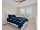 Bright bedroom with a white bed, ceiling fan, and a view outside the windows at 7517 Laureate Blvd # 4303, Orlando, FL 32827