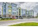 Well-maintained condo building with colorful exterior, manicured landscaping, and convenient covered parking for residents and guests at 7517 Laureate Blvd # 4303, Orlando, FL 32827