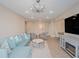 Bright living room with a blue sectional sofa, modern lighting, and an open floor plan at 7517 Laureate Blvd # 4303, Orlando, FL 32827