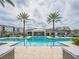 A beautiful large outdoor swimming pool surrounded by palm trees in a luxurious community at 7517 Laureate Blvd # 4303, Orlando, FL 32827