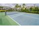 Outdoor tennis court surrounded by lush landscaping and greenery for an active lifestyle at 7517 Laureate Blvd # 4303, Orlando, FL 32827