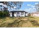 Cozy white home with black trim and expansive backyard, perfect for outdoor activities and relaxation at 1104 W 9Th St, Lakeland, FL 33805