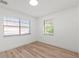 Bright bedroom featuring wood-look floors, neutral walls, and natural light from two windows at 1104 W 9Th St, Lakeland, FL 33805