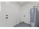 Utility room featuring a modern water heater, door to the exterior, and speckled flooring at 1104 W 9Th St, Lakeland, FL 33805