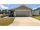 Attached two-car garage with concrete driveway and stone accents at 1047 Aruba Ave, Mulberry, FL 33860