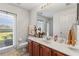 Bathroom with a white vanity, sink, toilet, and a window with natural light at 11321 Ledgement Ln, Windermere, FL 34786