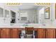 Bright bathroom featuring a large mirror, dual sinks, and wood cabinets at 11321 Ledgement Ln, Windermere, FL 34786
