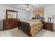 Bedroom featuring a large bed, window with drapes, and a wooden dresser and nightstand at 11321 Ledgement Ln, Windermere, FL 34786