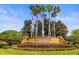 Community entrance sign with manicured landscaping and tall palm trees at 11321 Ledgement Ln, Windermere, FL 34786