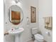 Cozy half bathroom featuring a pedestal sink, decorative mirror, and neutral decor at 11321 Ledgement Ln, Windermere, FL 34786
