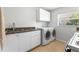 Practical laundry room with washer, dryer, sink, and ample cabinet space at 11321 Ledgement Ln, Windermere, FL 34786