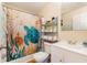 Cozy bathroom with decorative shower curtain, white vanity and additional storage shelf at 14285 Oconner Rd, Kathleen, FL 33849