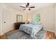 Bright bedroom featuring wood floors, ceiling fan, and a decorative area rug at 14285 Oconner Rd, Kathleen, FL 33849