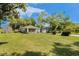 Quaint single-story home featuring a screened porch and large lawn, with a detached garage at 14285 Oconner Rd, Kathleen, FL 33849